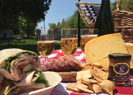 Image of an array of food on a picnic basket.